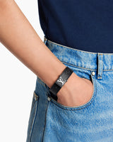 Pulsera LV Slim negra puesta en la muñeca